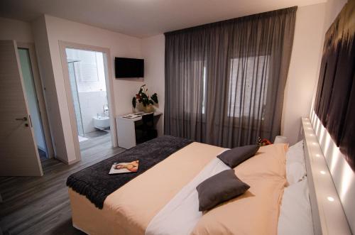 1 dormitorio con 1 cama grande y baño en B&B Il Soffione, en Fonzaso