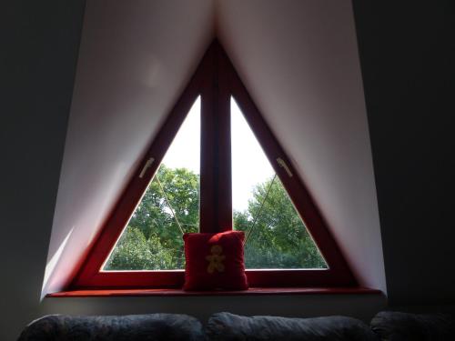 a window with a red pillow in a room at Totális Harmónia Villa in Miskolctapolca