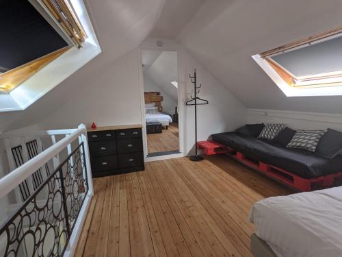 - une chambre mansardée avec un lit, un canapé et un miroir dans l'établissement Street app'Art, à Saint-Quentin