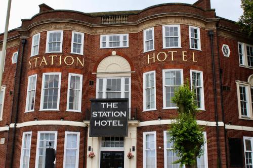 a red brick building with a sign for the station hotel at The Station Hotel and Banqueting in Dudley