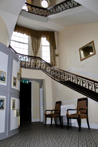 a staircase in a building with two chairs and a bench at The Station Hotel and Banqueting in Dudley