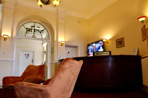 a living room with a tv and two chairs at The Station Aparthotel in Dudley