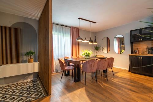 a kitchen and dining room with a table and chairs at Craita Merelor The PLACE in Aninoşani
