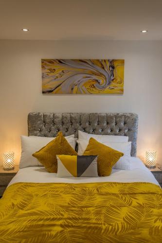 a bedroom with a large bed with a yellow blanket at Waterfront luxury apartment in Kinghorn