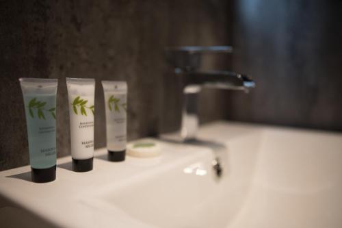 a bathroom sink with two bottles of soap and a faucet at Waterfront luxury apartment in Kinghorn