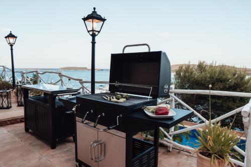 a grill with a plate of food on a patio at Menurka - Port d'Addaia in Port d'Addaia