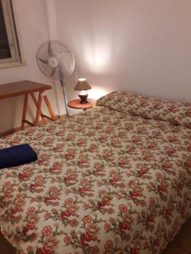 1 dormitorio con 1 cama con colcha de flores en Belgrano Apartment Near Metro, wi fi en Buenos Aires