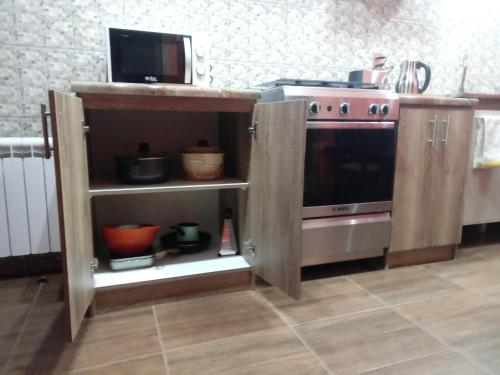 a kitchen with a stove and a microwave at VALYAK rent apart hotel - Servicios Integrales in Punta Arenas