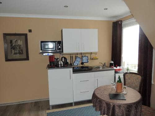 a small kitchen with a table and a microwave at Paul Lincke Residenz in Hahnenklee-Bockswiese