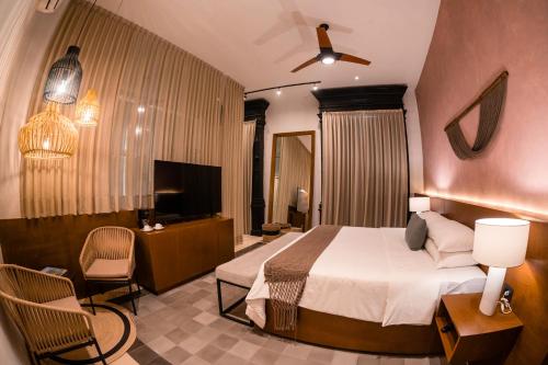a hotel room with a bed and a television at Piedra de Agua Merida in Mérida