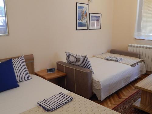 a room with two beds and a table at Apartmani Jelica FREE PARKING in Vranje