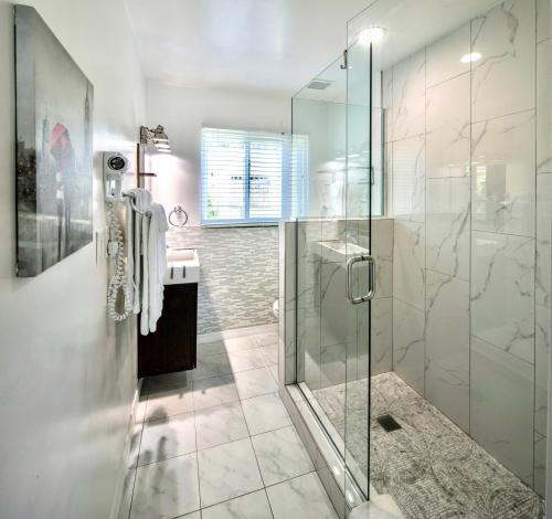 uma casa de banho com uma cabina de duche em vidro e um lavatório. em Park Shore Suites St Pete Beach em St Pete Beach
