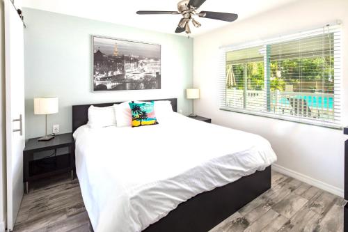 um quarto branco com uma cama e uma ventoinha de tecto em Park Shore Suites St Pete Beach em St. Pete Beach