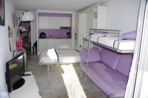 a room with two bunk beds and a kitchen at La Calypso in La Grande Motte