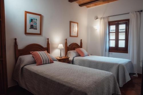 a bedroom with two beds and a window at Menurka-Santa Clara in Ciutadella