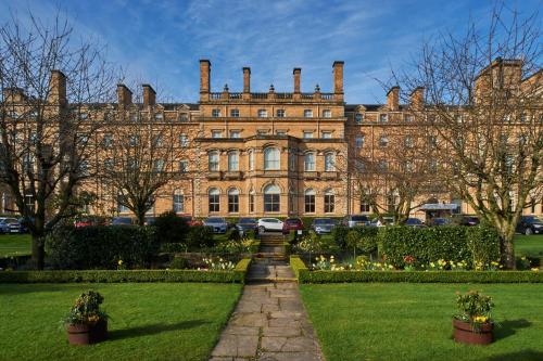 a large brick building with a garden in front of it at The Milner York in York