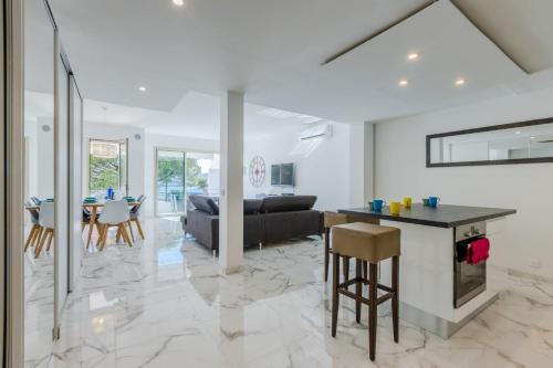 une cuisine et un salon avec une table et un canapé dans l'établissement 90m on the Croisette with Terrace & Sea View, à Cannes