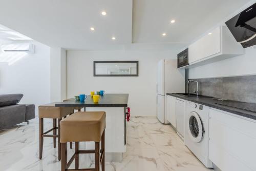 - une cuisine avec une table et un lave-linge/sèche-linge dans l'établissement 90m on the Croisette with Terrace & Sea View, à Cannes