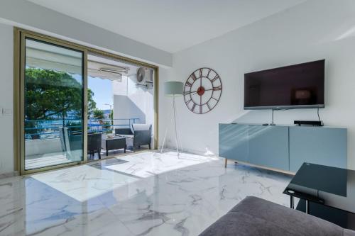 a living room with a tv and a large marble floor at Right by the beaches 90m2 on the Croisette in Cannes
