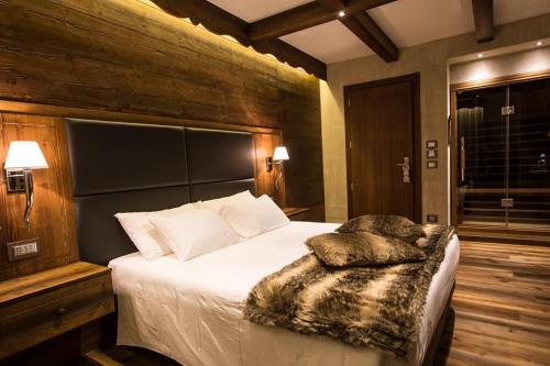 1 dormitorio con 1 cama grande con sábanas y almohadas blancas en Hotel Reale, en Lurisia
