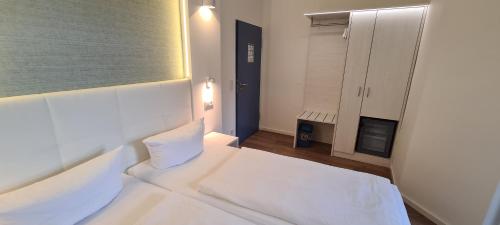 a white room with a bed and a window at Hotel Spreeufer in Lübben