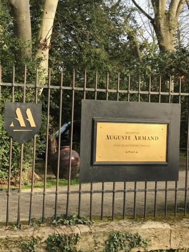 a sign in front of a fence with a park at Duplex au Coeur de Lunel in Lunel