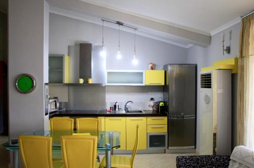 kuchnia z żółtymi szafkami i szklanym stołem w obiekcie Maria Beach Home in Golem w mieście Golem