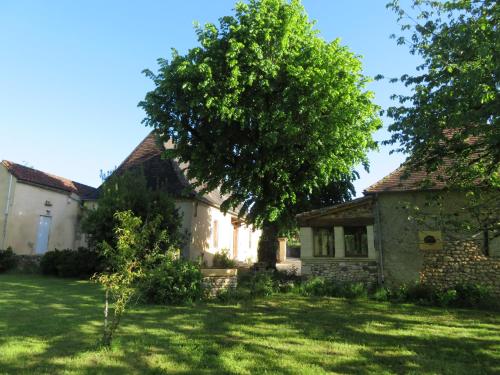 an old stone house with a tree in the yard at Au relais du croquant du Périgord, classée 3 étoiles in Cendrieux