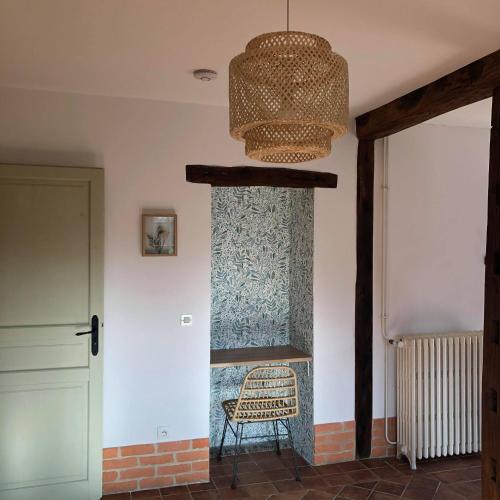 a room with a chair and a chandelier at L'ancienne Forge in Allemant