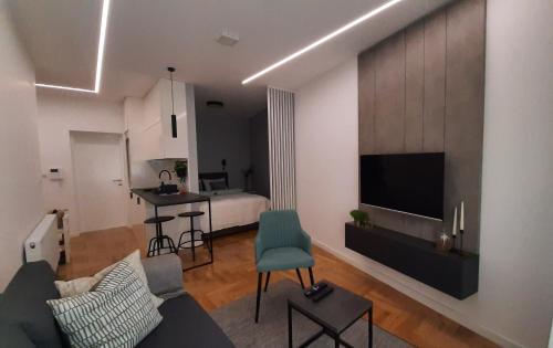 a living room with a couch and a tv and a bedroom at NINA Studio Apartment in Bijeljina