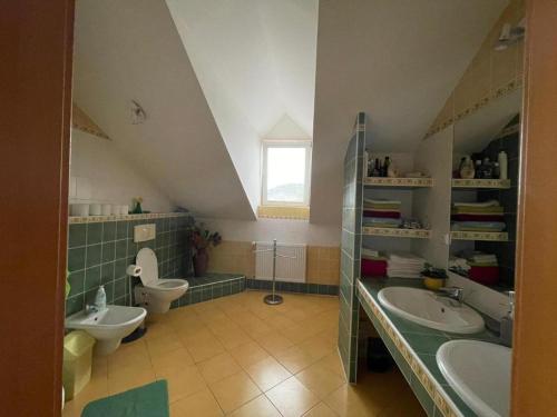 a large bathroom with two sinks and a toilet at Terezia in Jedľové Kostoľany