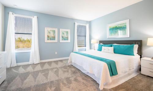 een slaapkamer met een groot bed met blauwe muren en ramen bij 8933CCD-The Retreat at ChampionsGate in Davenport