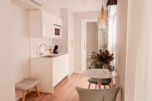 - une cuisine blanche avec une table et un évier dans l'établissement Aniana Alojamiento Boutique, à Logroño