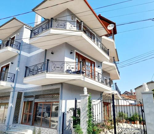 ein weißes Gebäude mit Balkonen darauf in der Unterkunft ODA Guest House in Korçë
