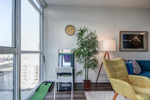 a living room with a couch a chair and a table at The Benetton Suite - Square One 1 BR + Den + 1 Parking in Mississauga