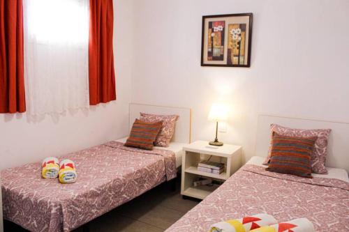 a bedroom with two beds and a table with a lamp at Apartamento MareVerde Las Americas in Adeje