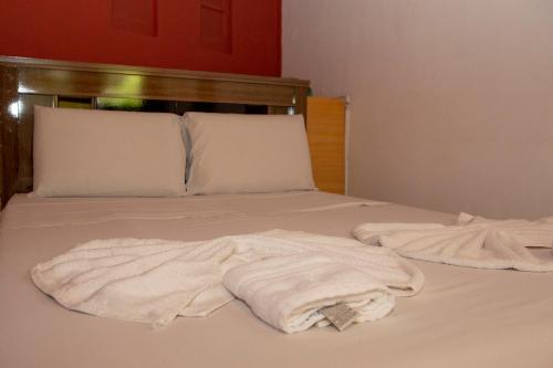 a bed with two white towels on it at Planeta Macacos in Macacos