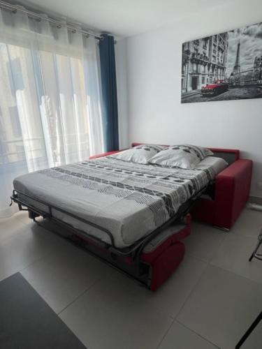 Ce lit se trouve dans un dortoir doté d'un cadre rouge. dans l'établissement Beautiful Bright Apt At 3 Min Walk From The Beach, à Antibes