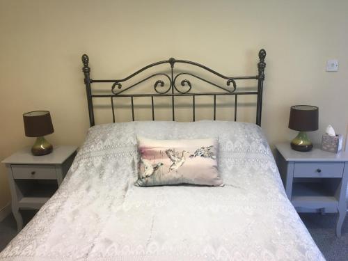 a bed with a pillow on it with two night stands at Charming 1-Bedroom Apartment near South Downs in Hailsham