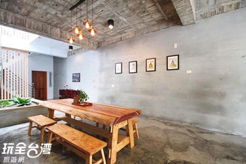 a dining room with a wooden table and benches at Anping Light in Tainan
