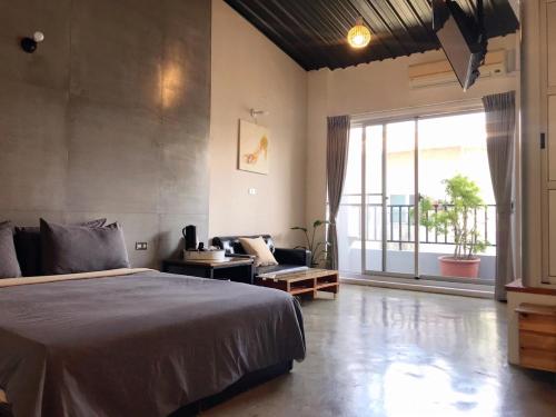 a bedroom with a bed and a couch and a window at Anping Light in Tainan