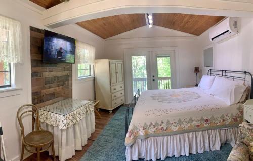 a bedroom with a bed and a table and a tv at Lamb's Rest Inn in New Braunfels