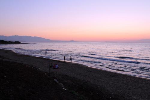 two people walking on the beach at sunset at Babis Hotel in Skaleta