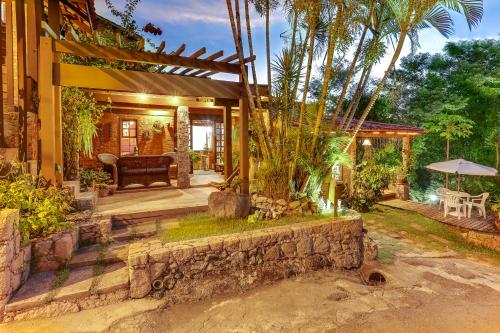 a house with a patio with a couch and trees at Morada das Pedras in Florianópolis