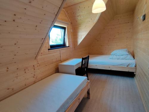 una habitación con 2 camas y un escritorio en una cabaña en Osada Jantar-Resort&SPA en Jantar