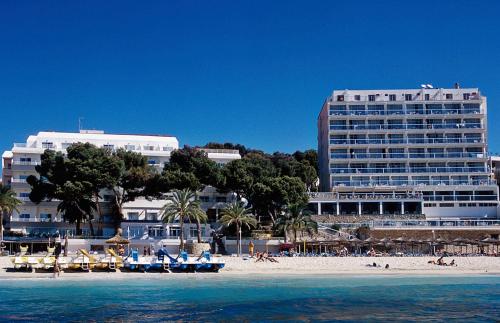 a beach with buildings and people on the beach at Flamboyan Caribe Hotel & Spa in Magaluf