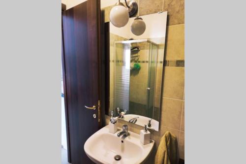 W łazience znajduje się umywalka i lustro. w obiekcie Large house 3 floors City 'n sea w mieście Vitinia