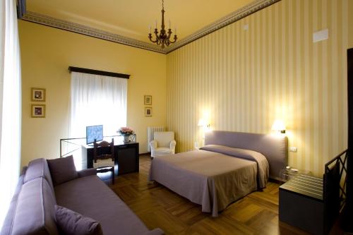 a hotel room with a bed and a couch at Alla Marina Bed And Breakfast in Trapani
