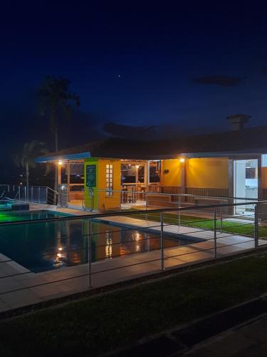 a building with a swimming pool at night at Ecohotel Guaduales Pereira in Pereira