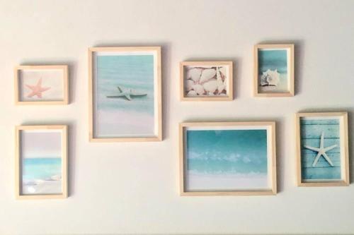 un muro con cuatro cuadros del océano en Almarena, tu casa en Punta del Este, en Manantiales